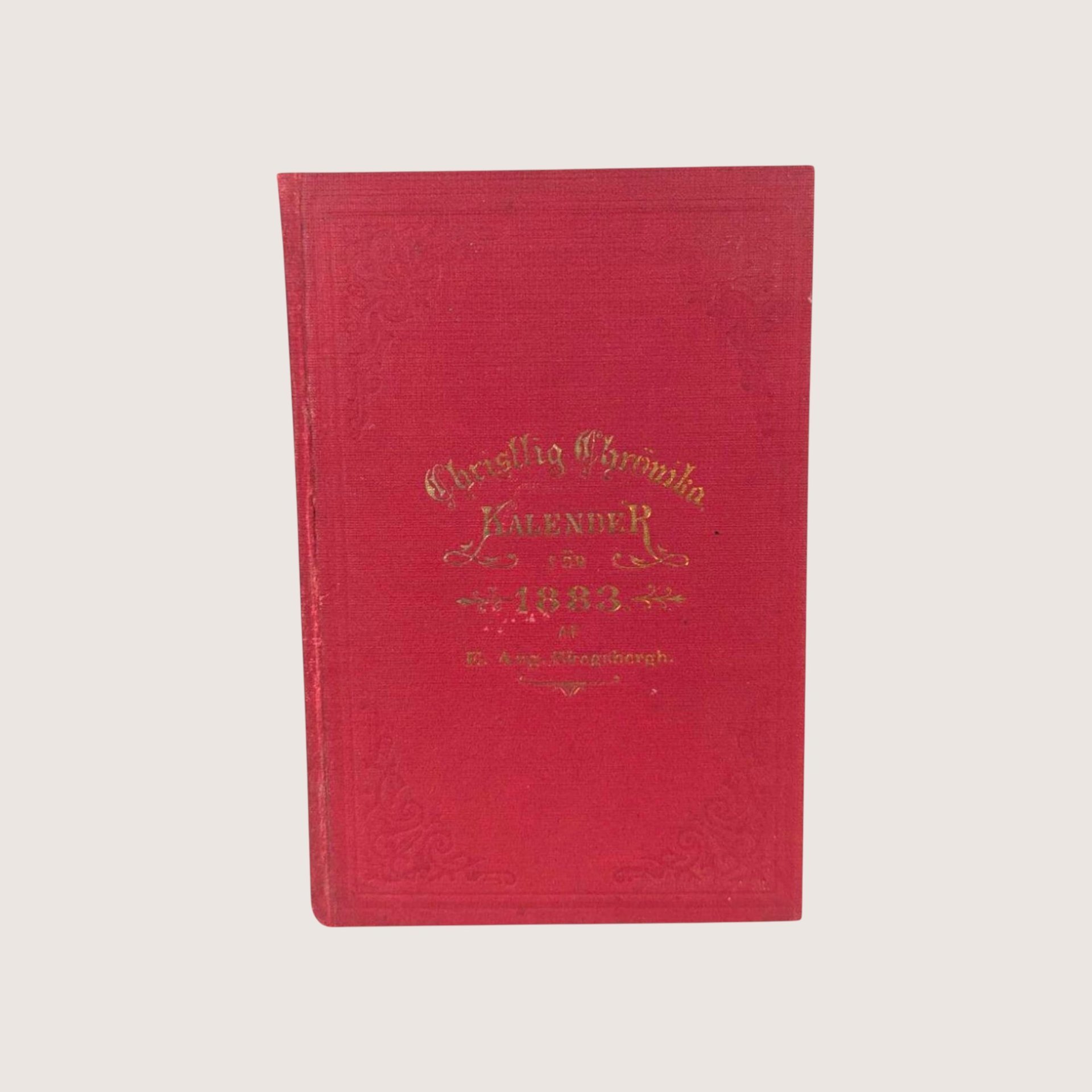 Antique red cloth hardcover book with gold gilt lettering titled Christlig Chronika Kalender for 1883.