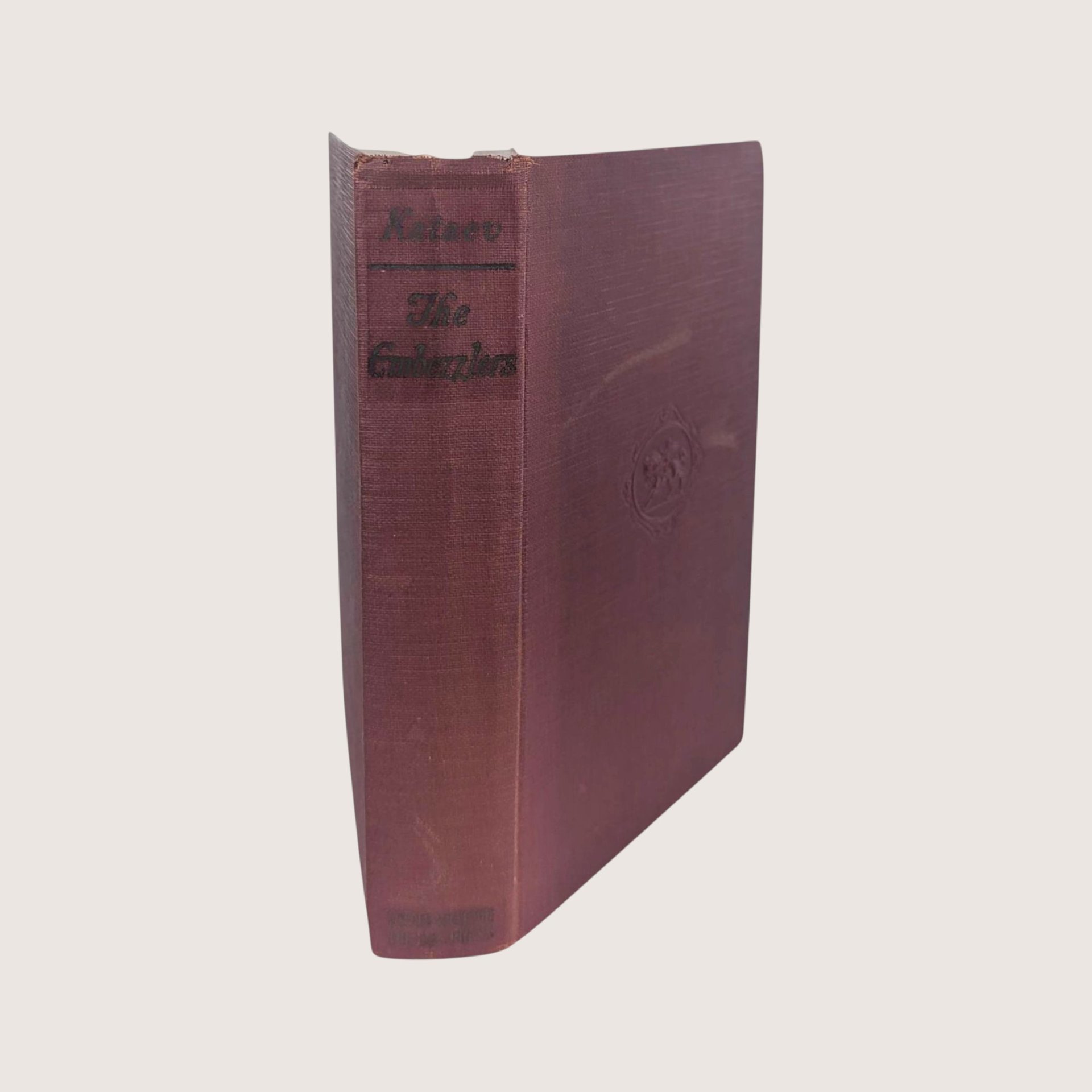 A 1929 first American printing hardcover edition of The Embezzlers by Valentine Kataev bound in textured maroon cloth.