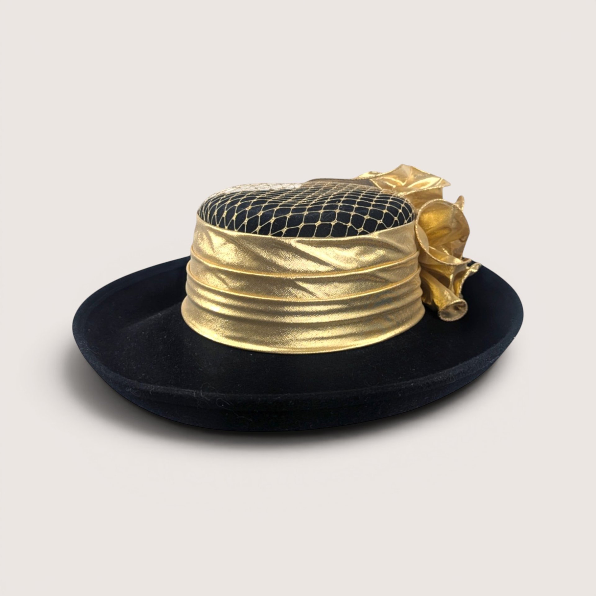 A vintage Sonni San Francisco black wool hat featuring a metallic gold draped band, gold netting, and side bow.