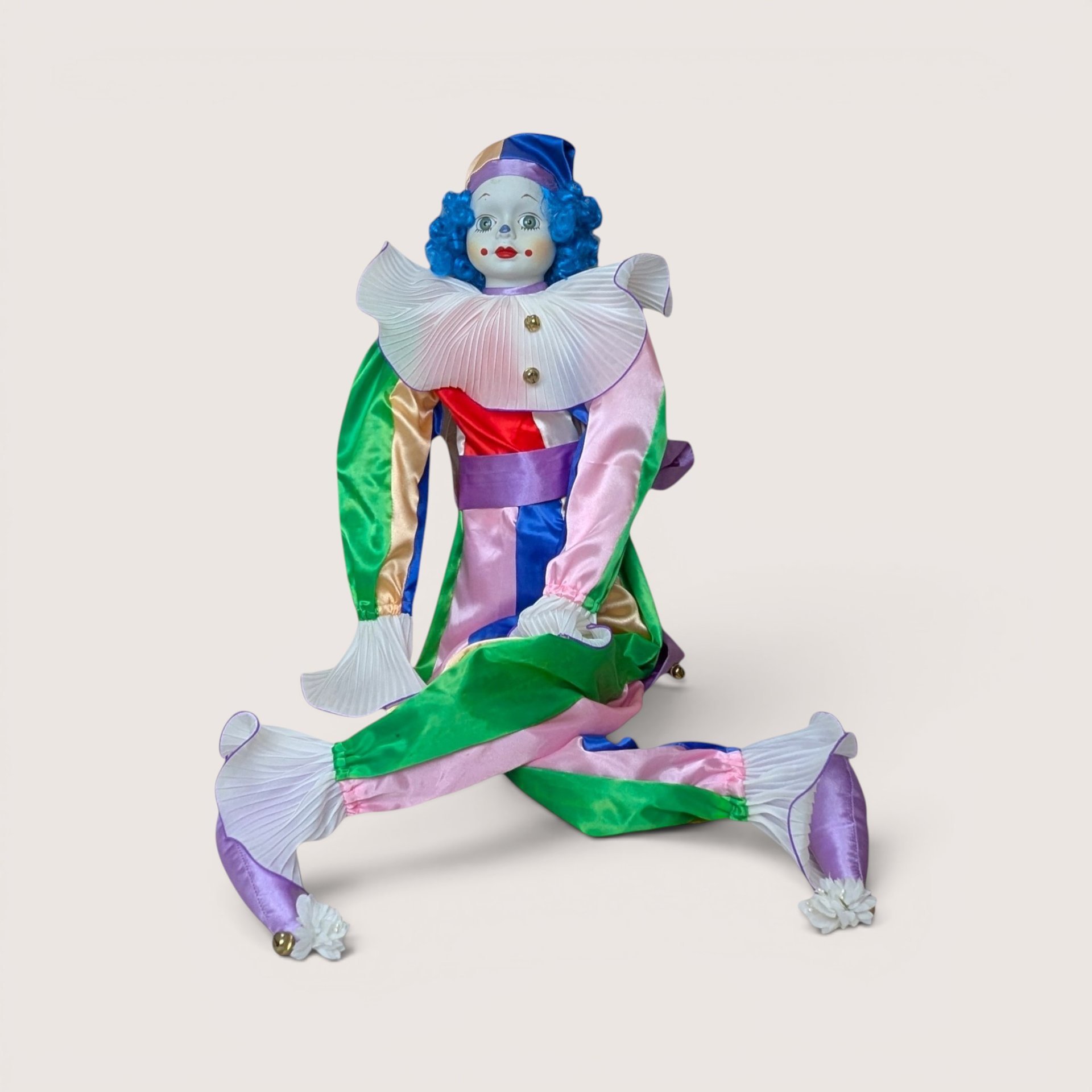 A vintage Bette Ball Victoria Ashlea Originals porcelain clown doll named Jody with blue hair and a colorful satin outfit.