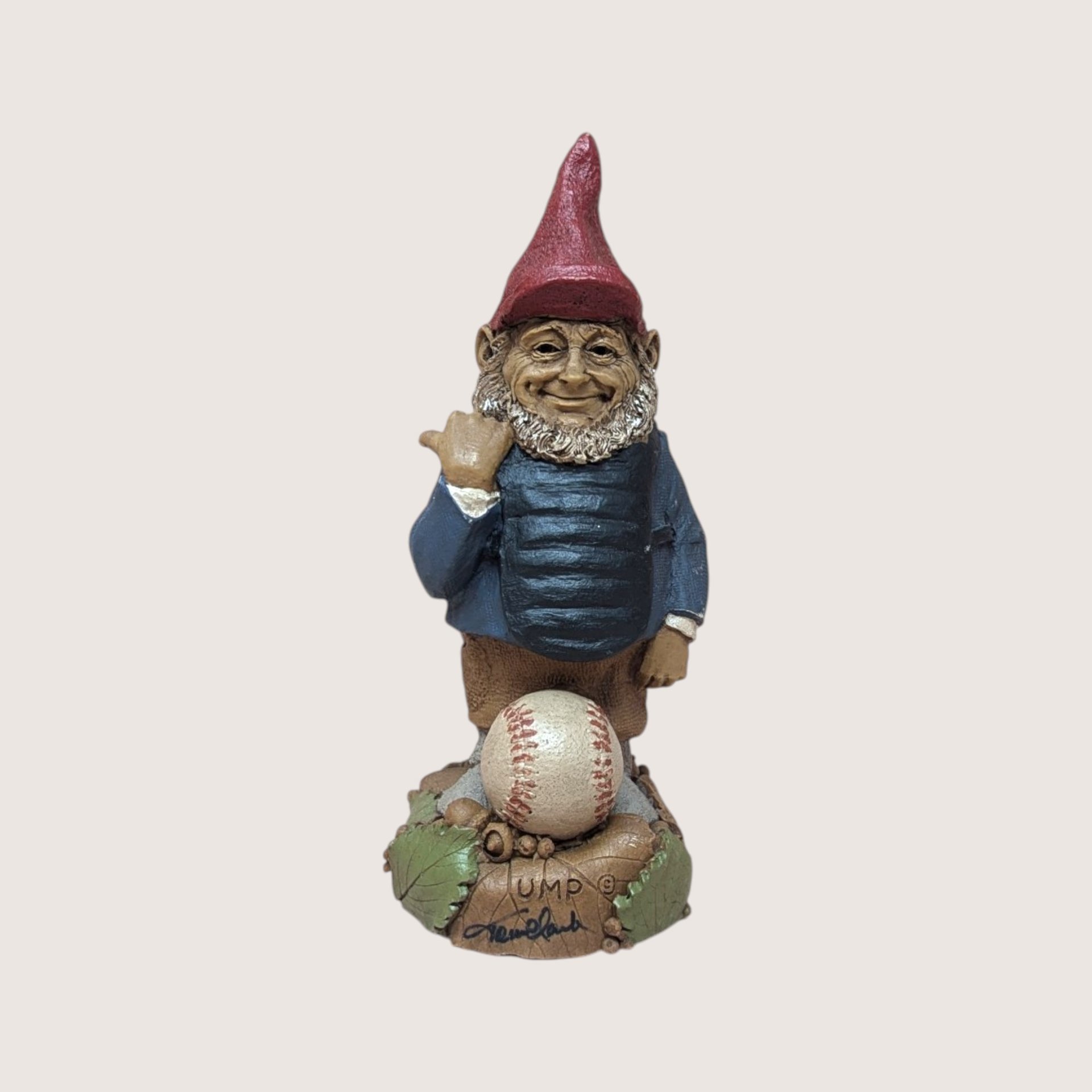 Vintage Tom Clark signed Ump baseball umpire gnome figurine standing behind a baseball on a linen background