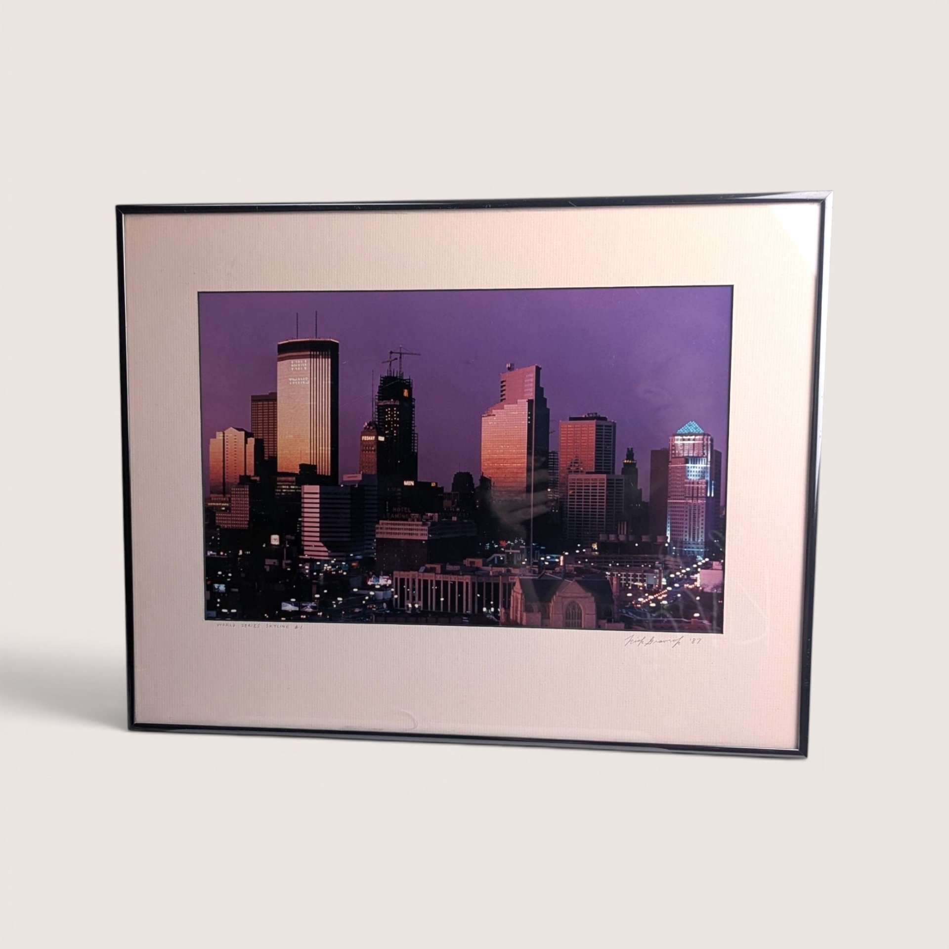 A framed photograph of the Minneapolis skyline under a purple twilight sky