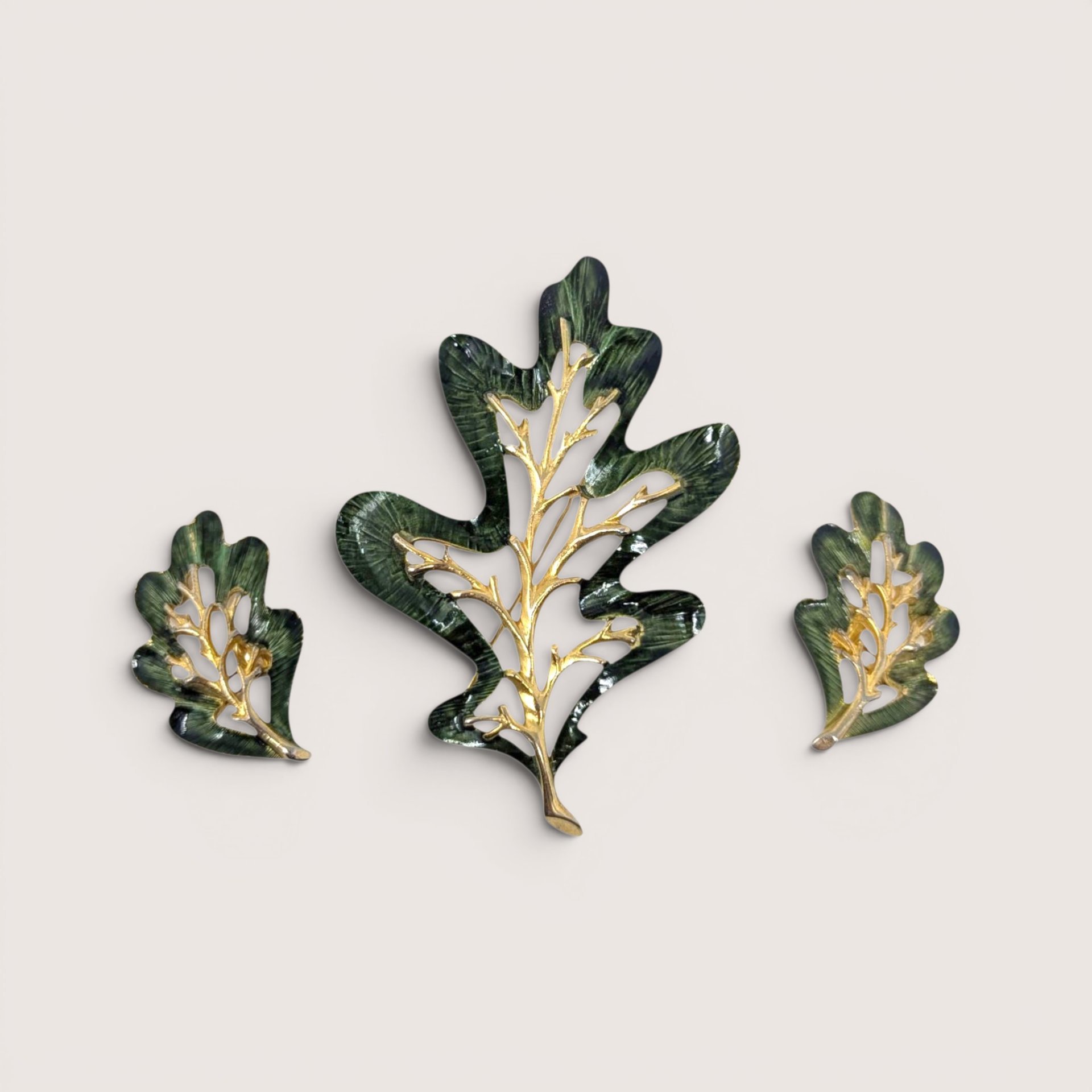 Vintage Sarah Coventry Enchanted Forest green enamel oak leaf brooch and clip on earrings set on a linen background