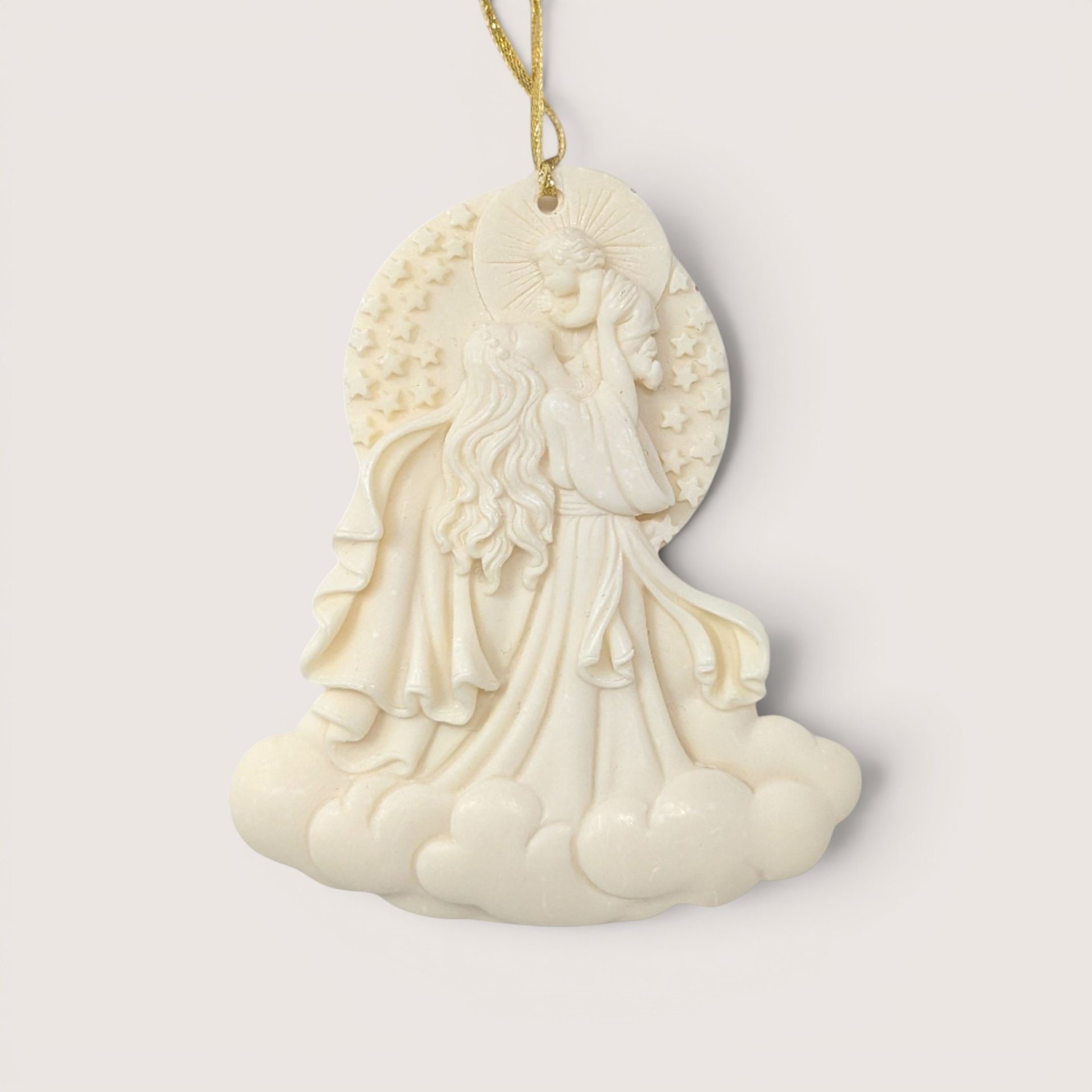 A 2000 Roman Inc "Cause of Our Joy" Millennium Series ornament on a soft pink background. The cream-colored resin cameo style sculpture depicts a flowing Madonna figure raising the infant Christ child into the sky above a base of billowy clouds.