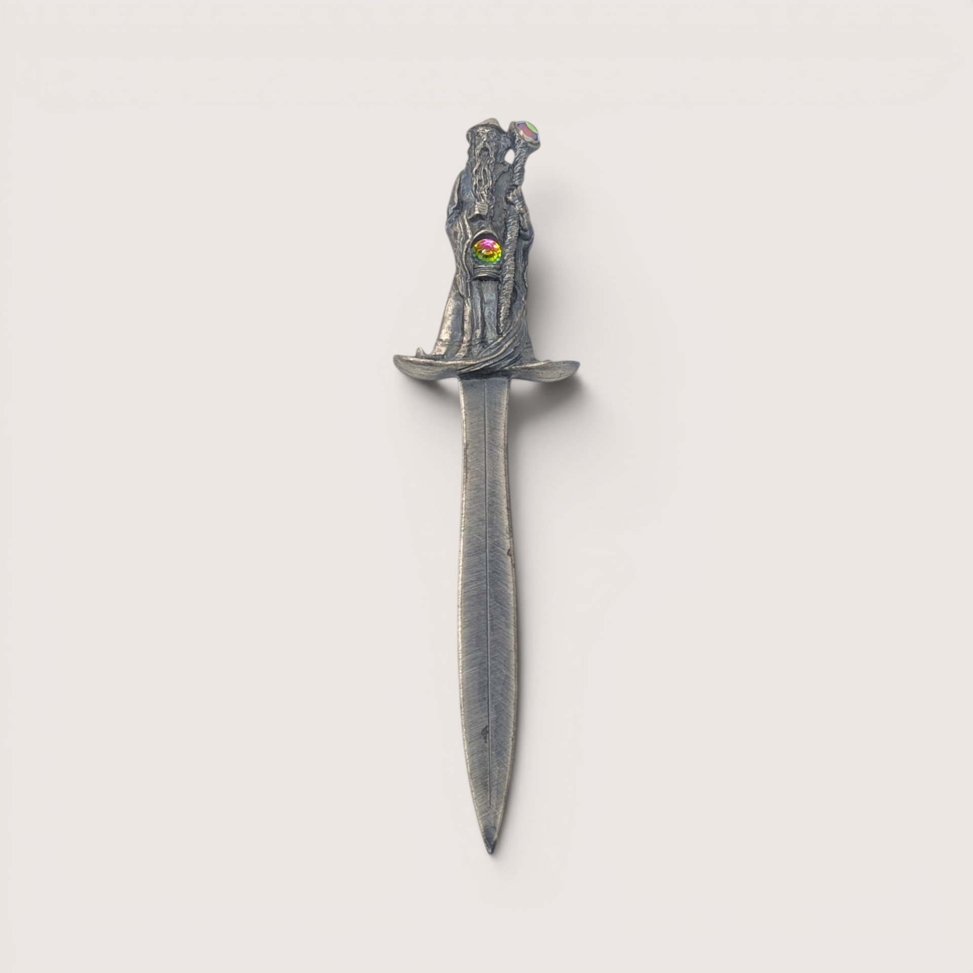 A vintage pewter letter opener featuring a sculpted wizard handle set with two iridescent crystal rhinestones on a plain background
