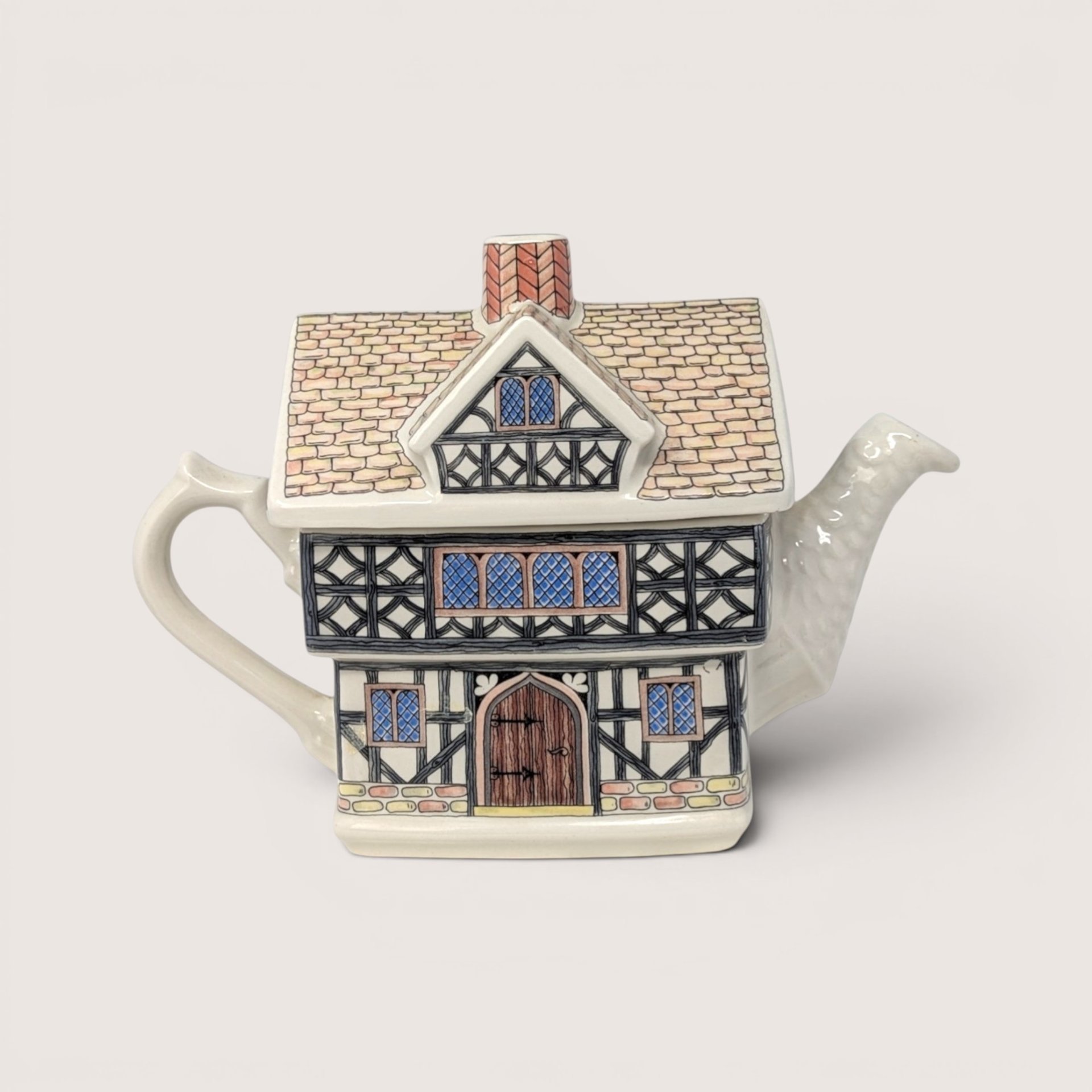 A vintage Sadler ceramic teapot shaped like a two-story English Tudor house with half-timbered architectural details.