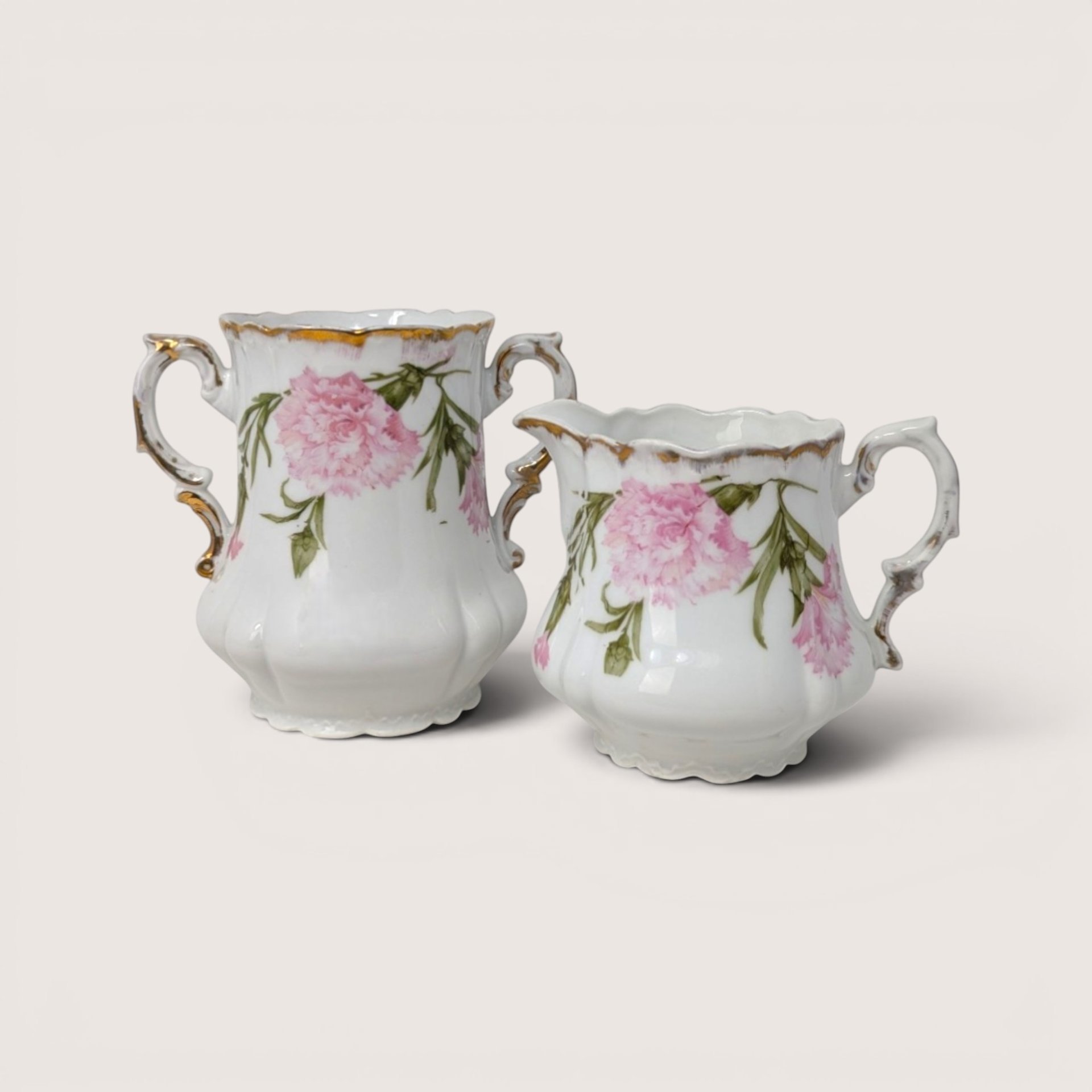 Antique Royal Bavarian PM porcelain sugar bowl and creamer set with pink floral designs and gold accents.