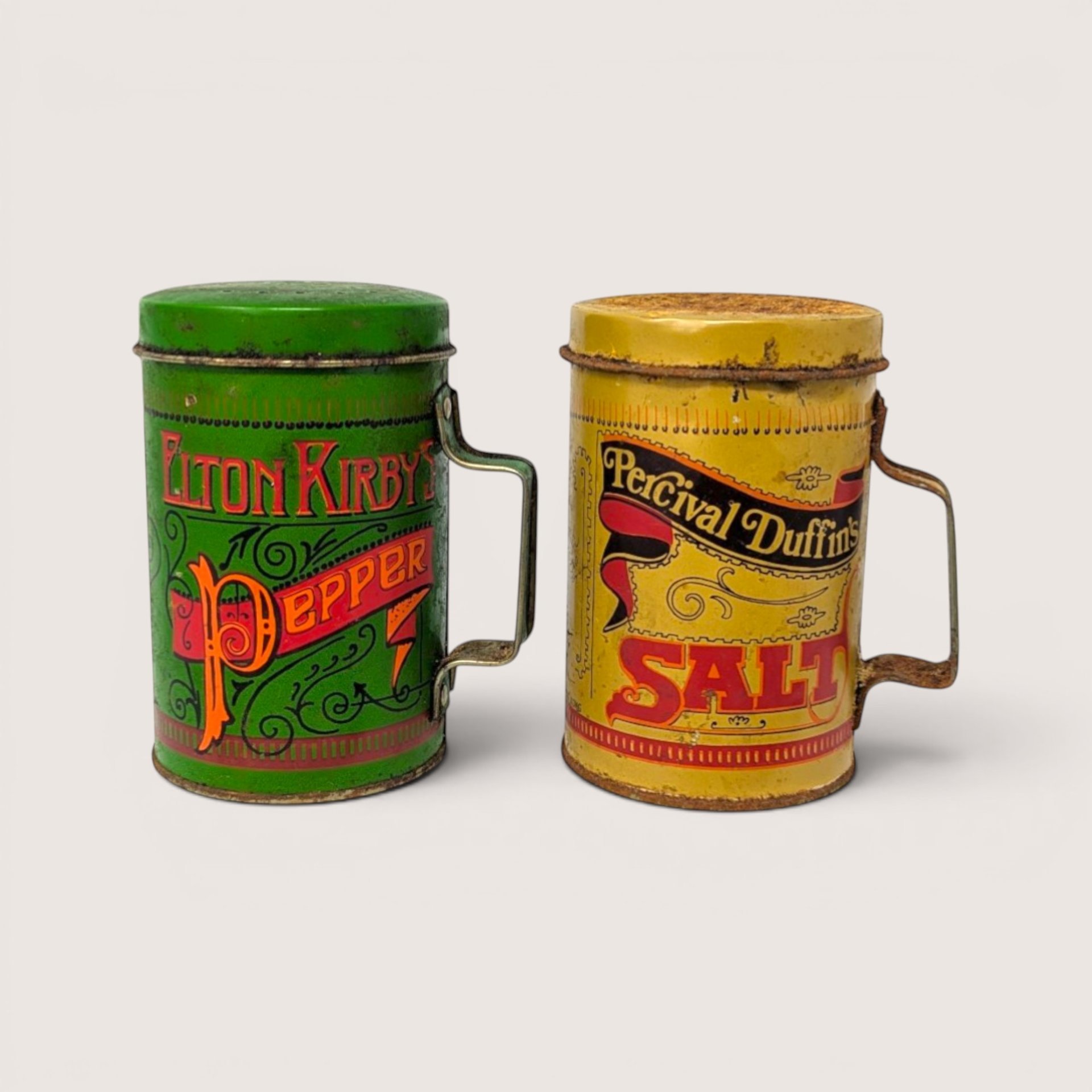 Vintage green Elton Kirby pepper and yellow Percival Duffin salt tin shakers with heavy rust accents.