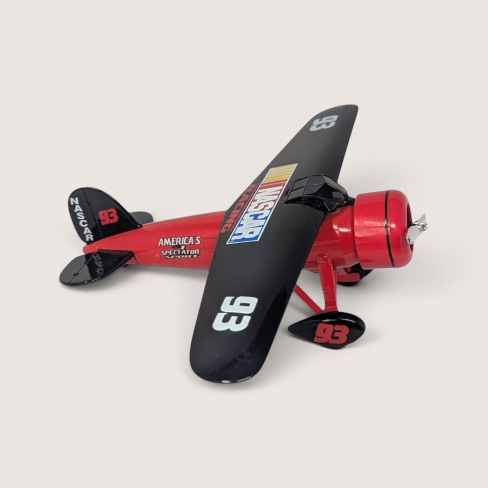 Vintage 1990s Ertl NASCAR Travel Air Model R Mystery Ship die-cast airplane coin bank in red and black livery with box.