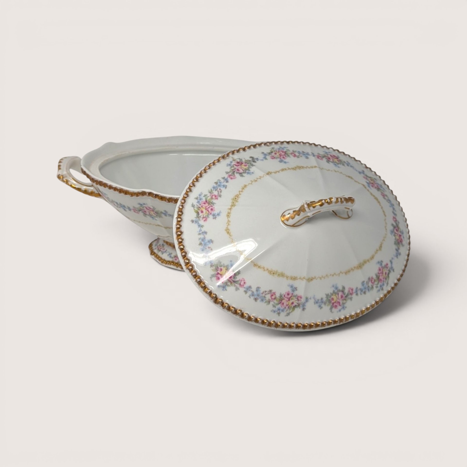 Antique Elite Works Limoges porcelain covered vegetable bowl with pink floral swags and gold trim, shown with its lid resting beside it.