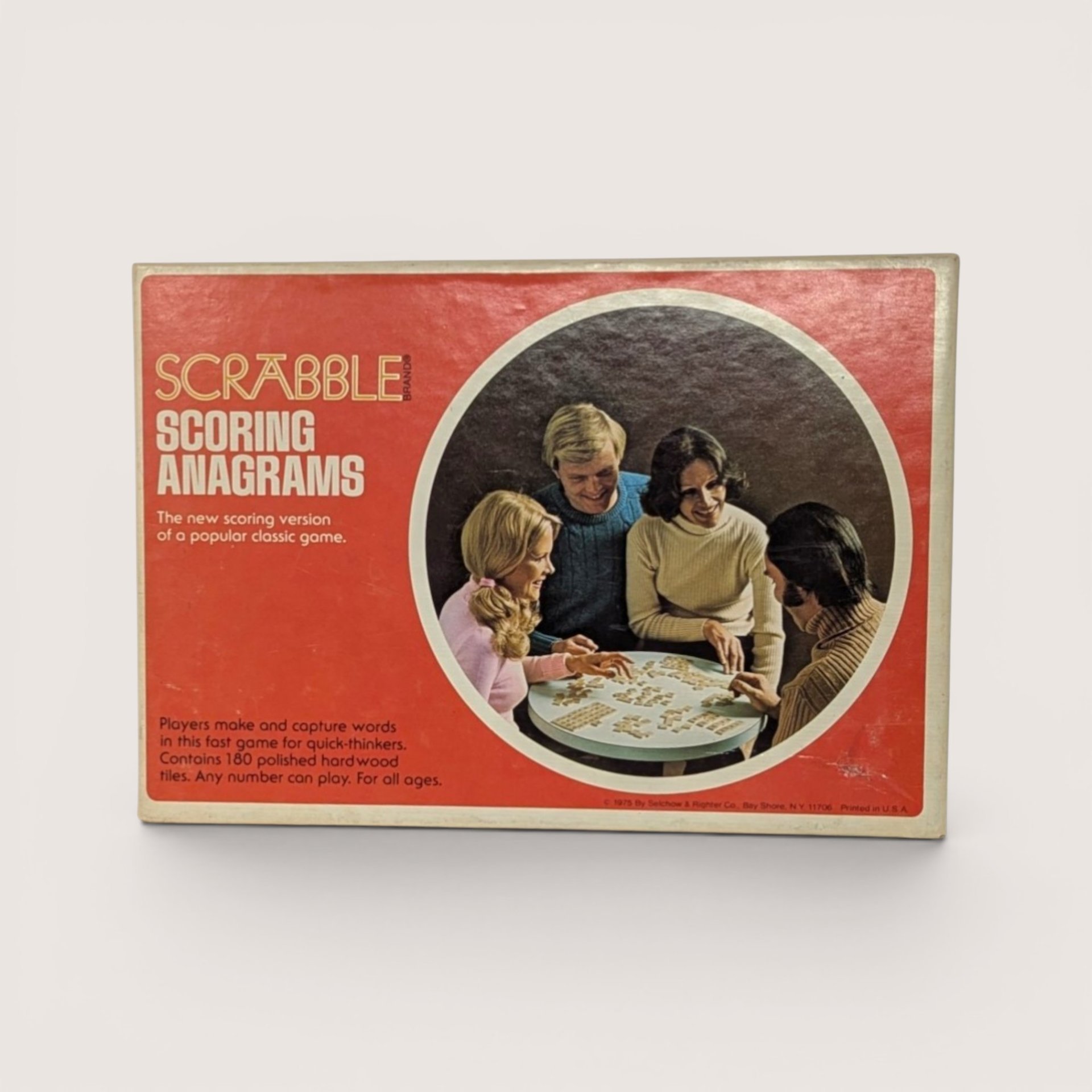 Vintage 1975 Scrabble Scoring Anagrams game box in red with a circular photo of four people playing at a table.