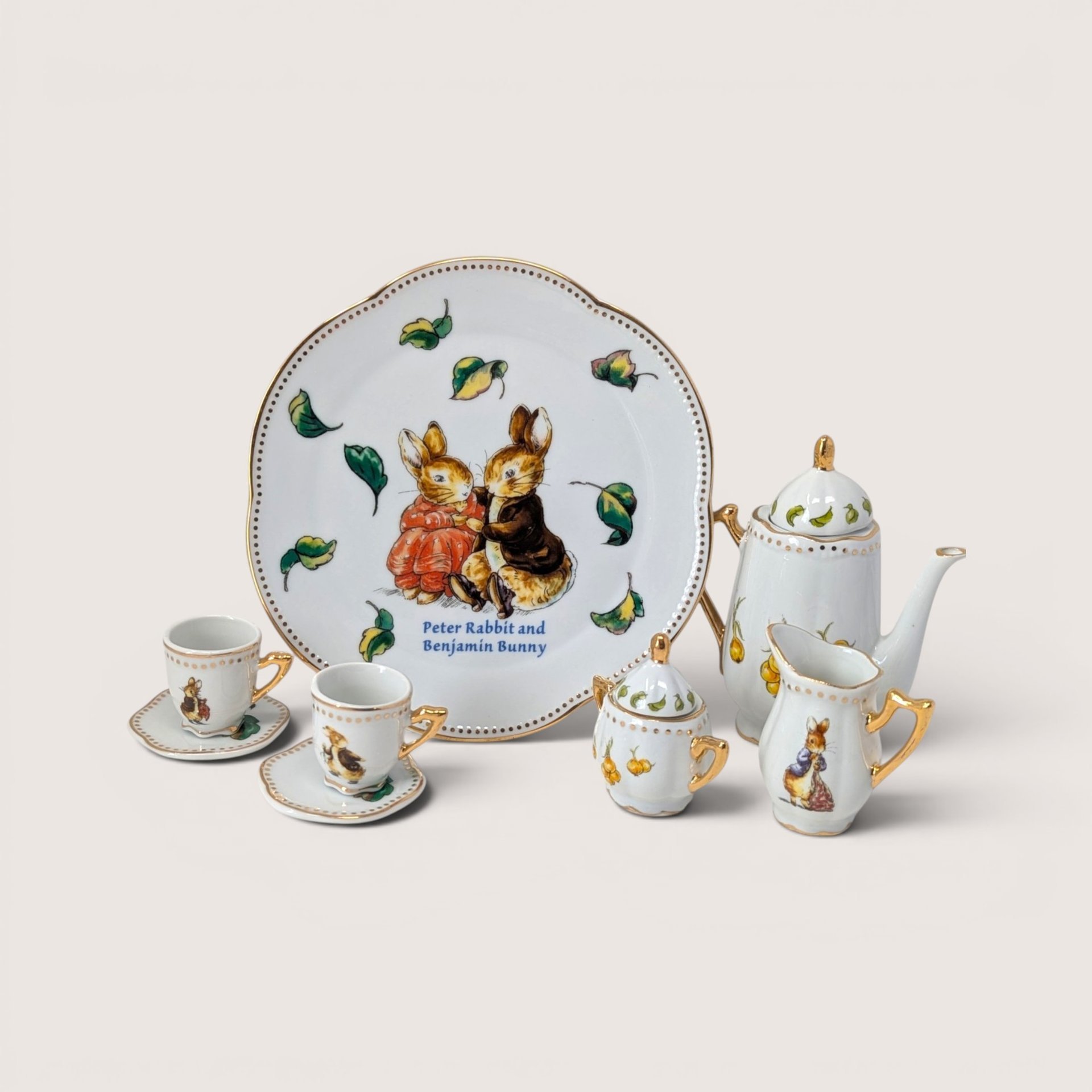 Vintage 2002 Beatrix Potter 10-piece porcelain mini tea set with gold trim featuring Peter Rabbit and Benjamin Bunny illustrations.