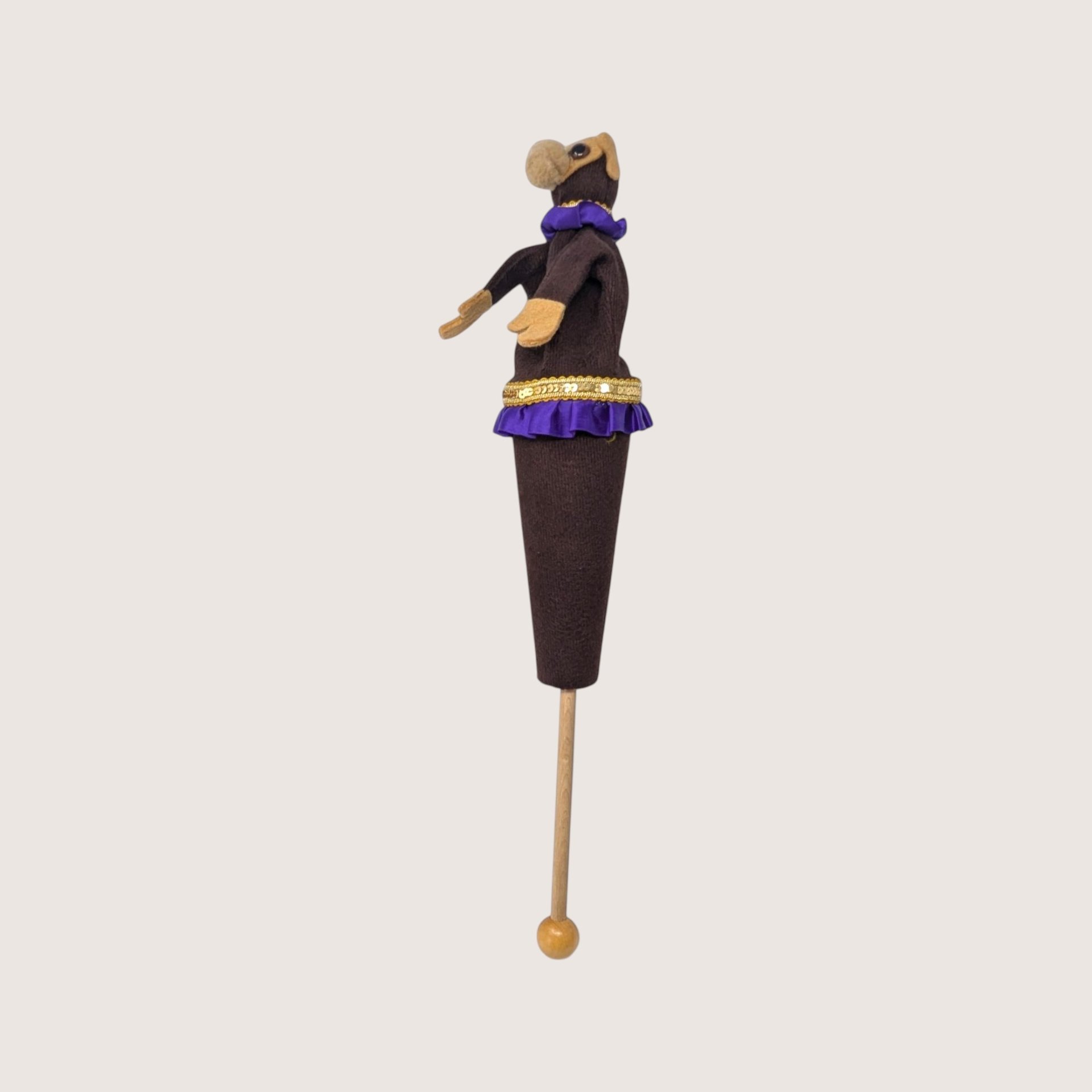 Vintage handmade felt monkey stick puppet with purple ruffled trim and gold sequins on a wooden rod.