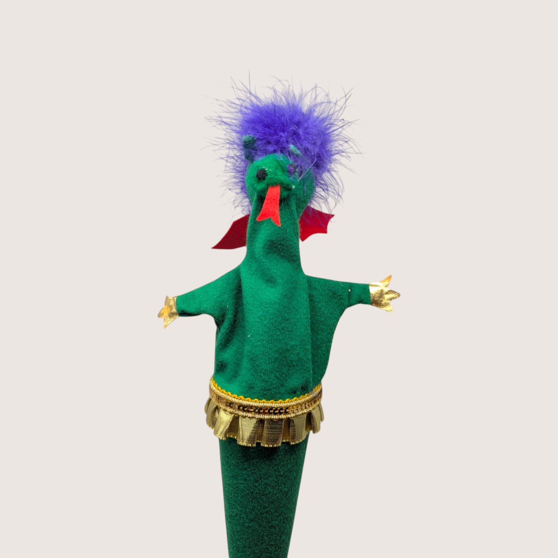 Vintage handmade felt dragon puppet in green with a purple feather mane, red tongue, and gold trim.