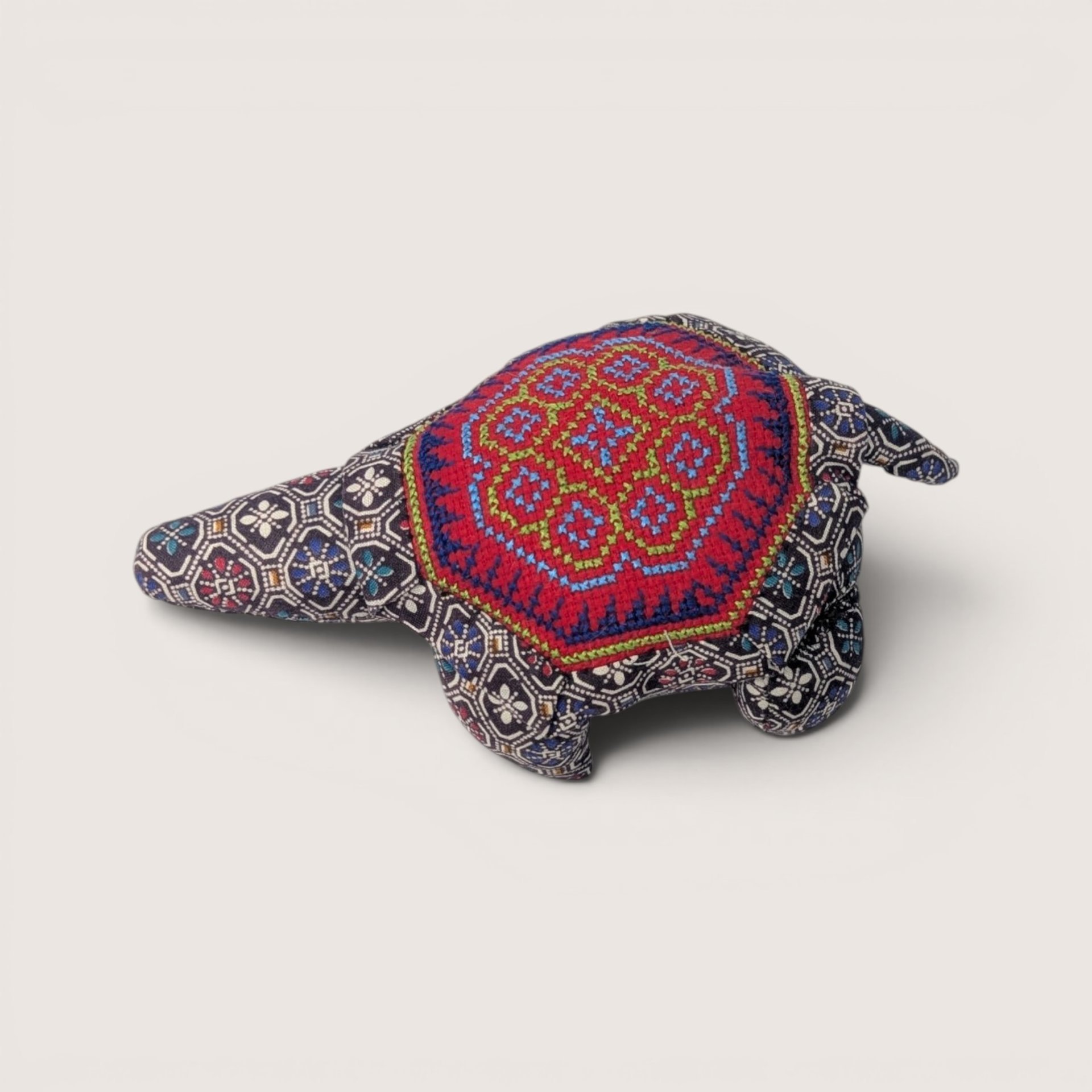 Handmade vintage textile turtle pin cushion with intricate red and blue cross-stitch embroidery