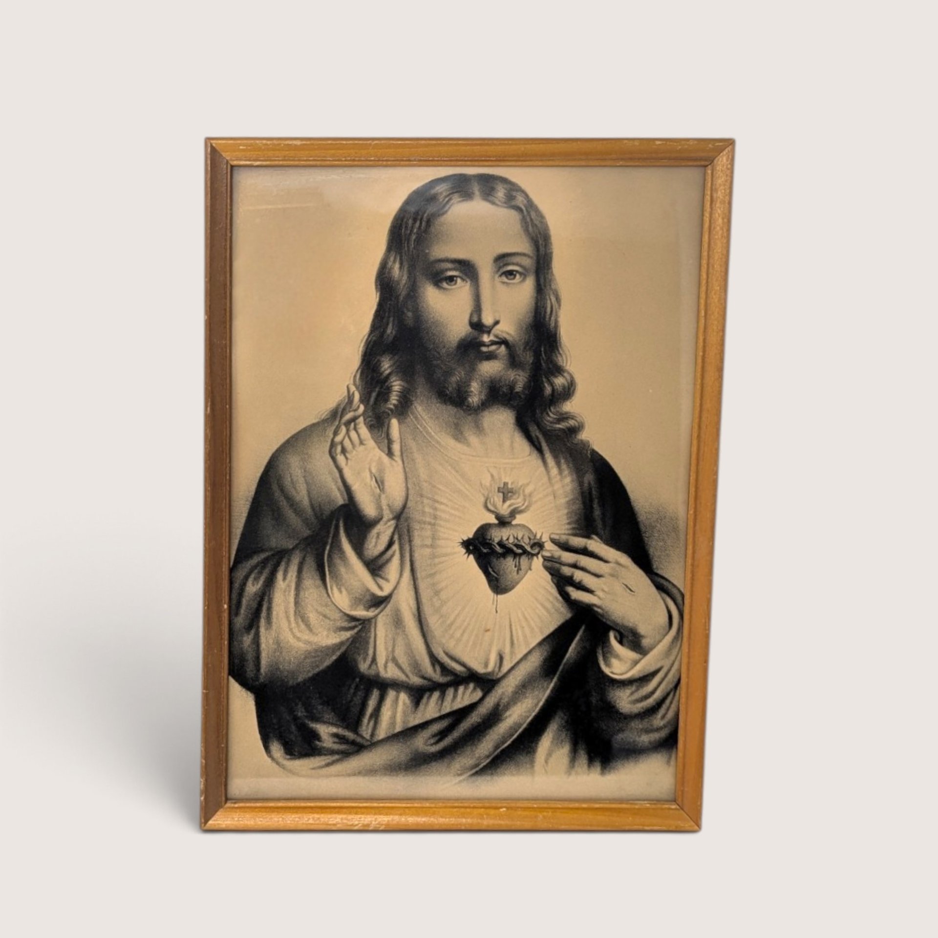 Vintage sepia tone framed print of the Sacred Heart of Jesus in a wood frame behind glass.