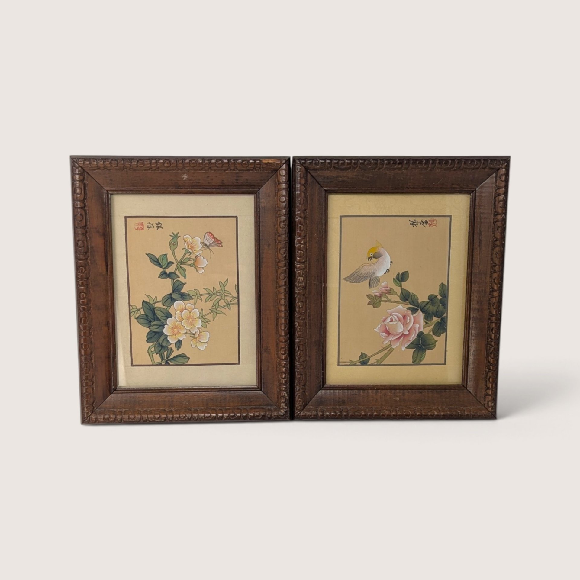 Pair of vintage Asian wood framed botanical and bird art prints with carved frames.