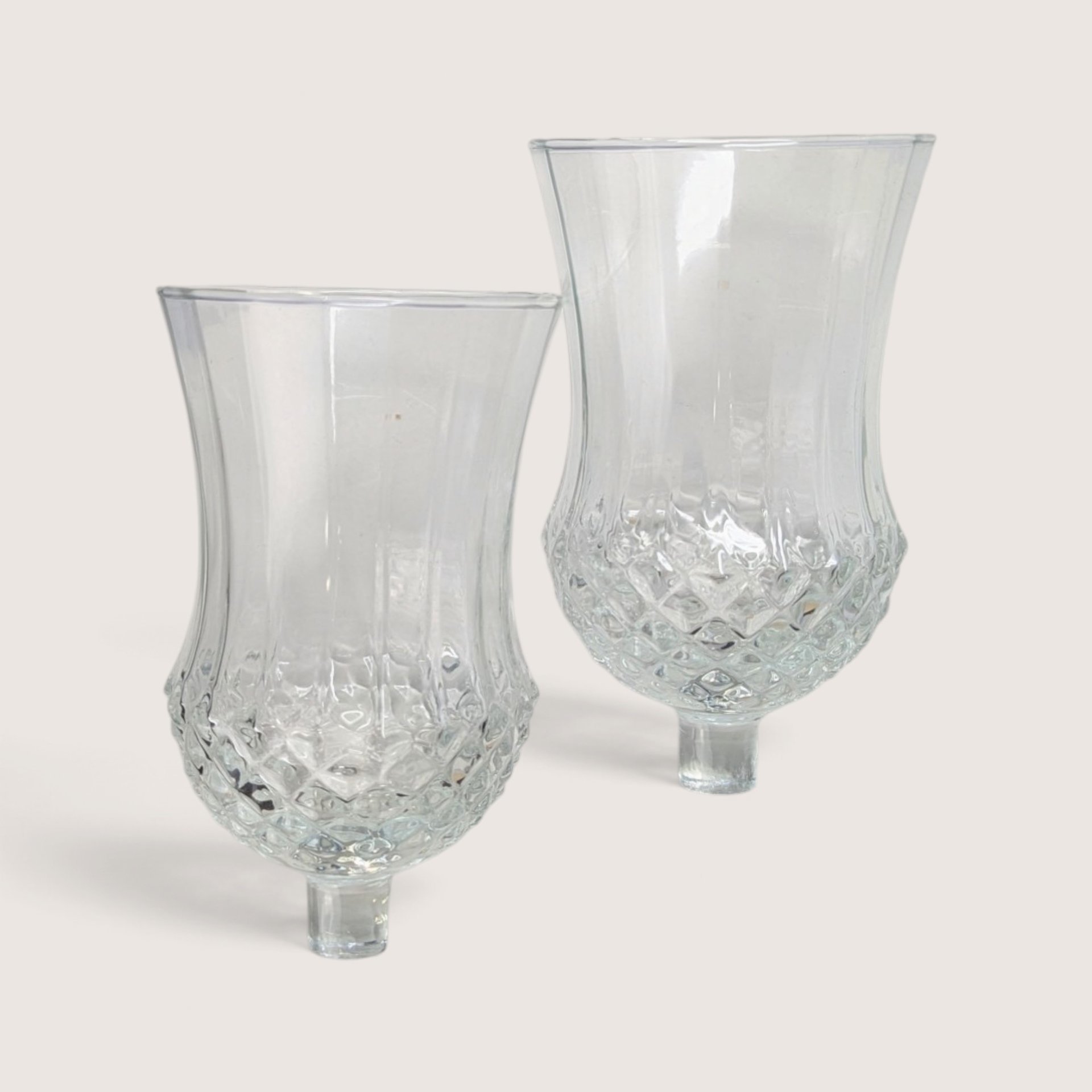 Pair of vintage clear glass peg votive candle holders with textured diamond cut lower bowls.
