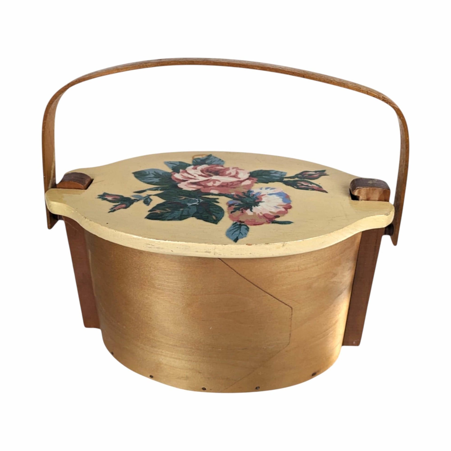 A vintage wooden woven basket with a hinged lid featuring a hand-painted floral design of a pink rose and blue flowers, with a stationary arched wood handle.