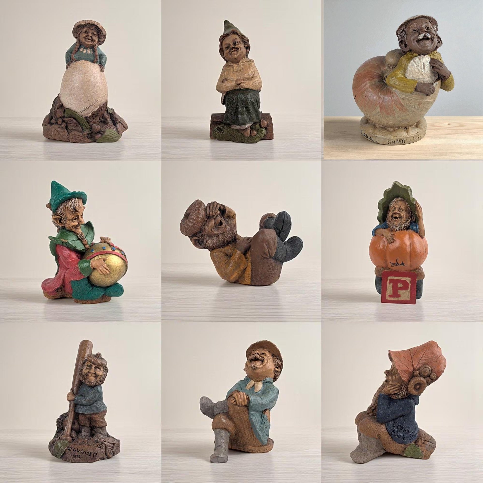 A grid of nine individual photos showcasing various resin gnome and character figurines by artist Tom Clark. The figures include a gnome leaning on a large egg, one sitting on a wooden log, a character emerging from a seashell, a gnome painting a large gold ornament, a laughing figure reclining, a gnome sitting on a pumpkin atop a red block, a baseball-themed gnome with a bat, and two figures designed as shelf-sitters.