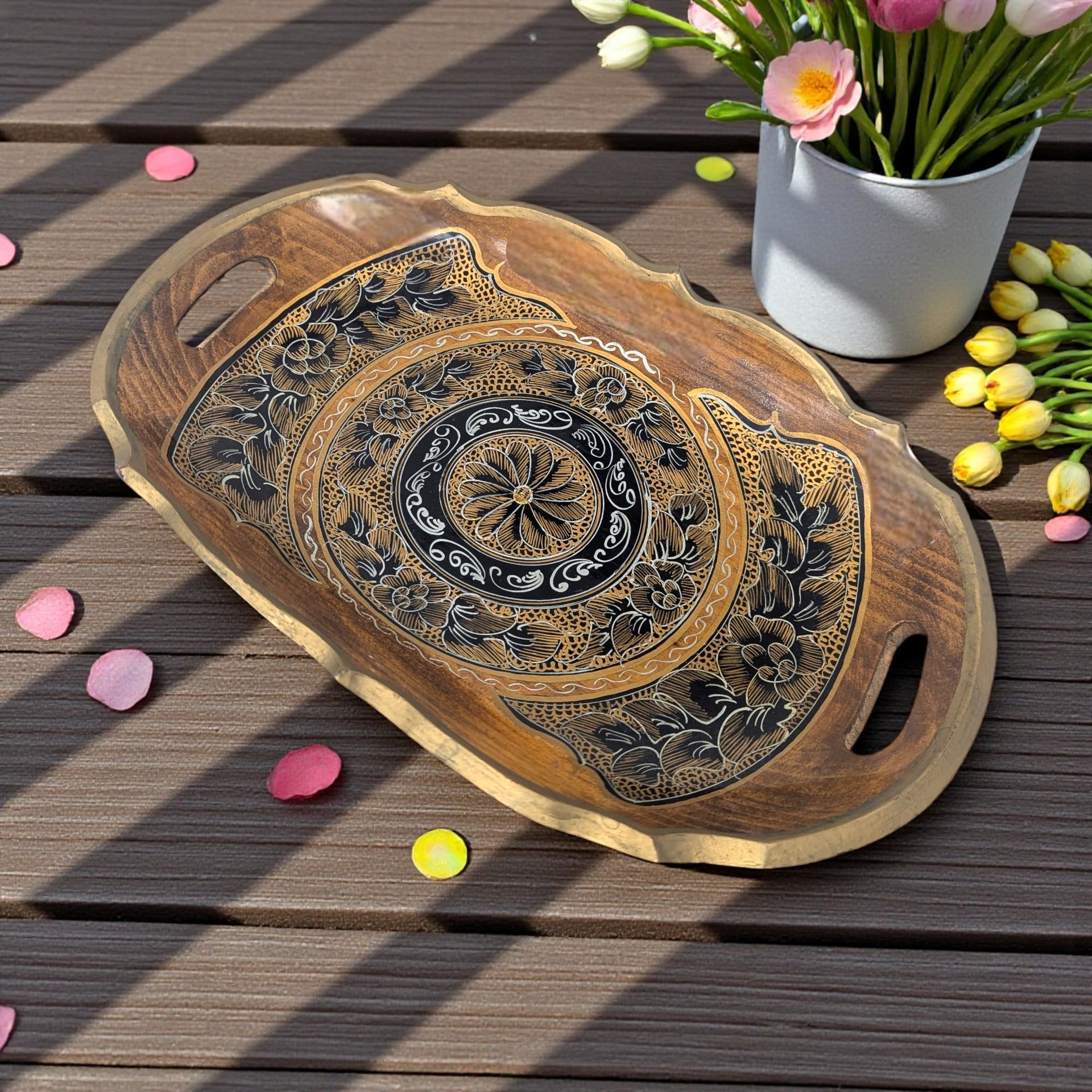 A rectangular shallow wooden tray with a dark finish. The center features handpainted gold and black botanical motifs, including delicate floral scrolls and leaf patterns against the natural wood grain.