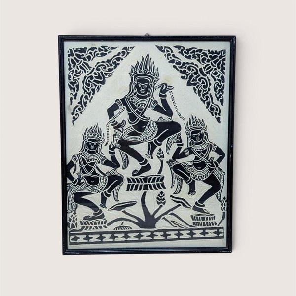A vertical framed art piece on textured rice paper featuring three Apsara dancers in traditional Cambodian headdresses and poses. Bold black ink on a cream-white background. Framed in a minimalist black wood frame.