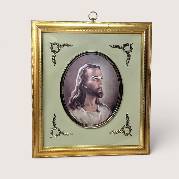 Framed Warner Sallman Head of Christ portrait in an oval matte with decorative corner flourishes and a gold frame.