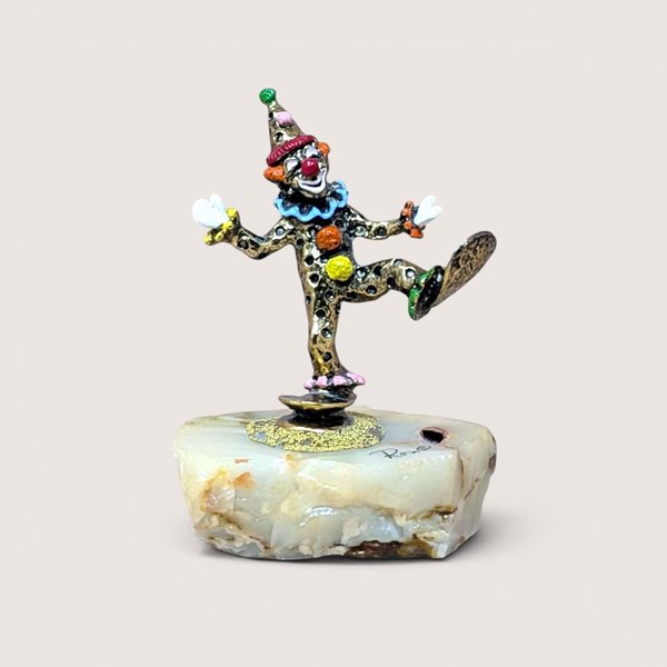 A hand-painted metal clown figurine by Ron Lee with 24k gold plating on a thick, natural onyx marble base against a neutral background.