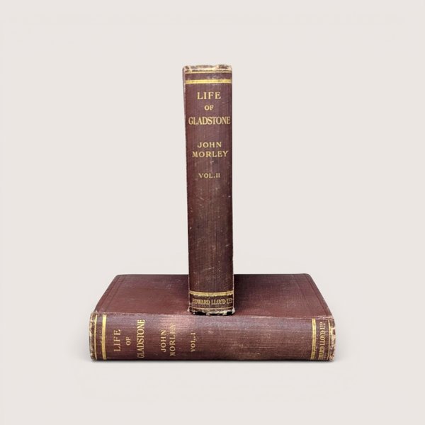 Two antique volumes of Life of Gladstone by John Morley with worn brown covers and gold lettering on the spines.