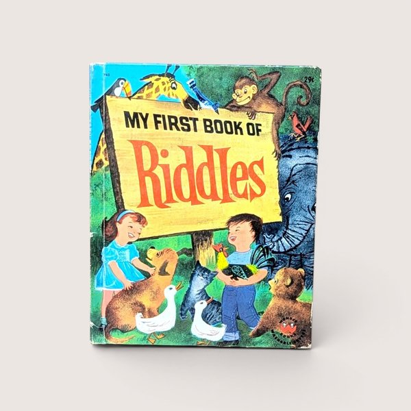 A vintage 1960 children's book titled My First Book of Riddles featuring a colorful cover with animals and two children holding a rooster and a duck