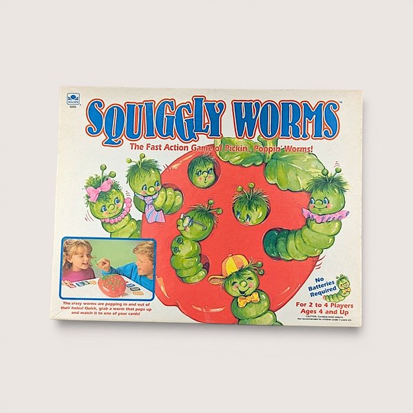 Vintage Squiggley Worms board game box showing cartoon green worms on a large red apple over a plain background.