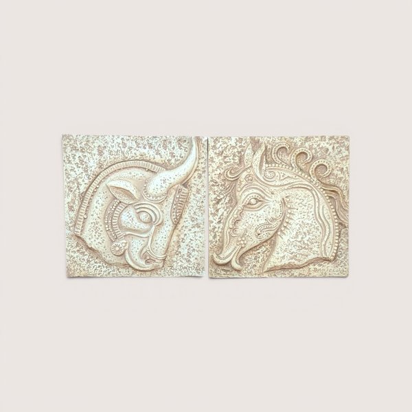 A pair of square vintage plaster wall plaques by Z. Danjell featuring stylized relief carvings of a horse and a bull in a Greek Brutalist style.