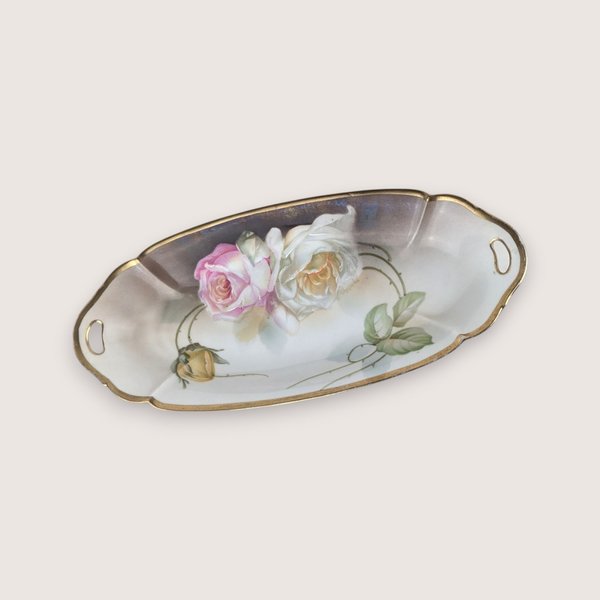 Antique porcelain celery dish from Suhl Germany featuring hand-painted roses and a gold-trimmed rim with handles.