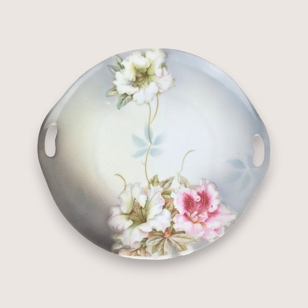 Antique round German porcelain handled tray featuring hand-painted pink and white floral blossoms with a worn gold rim.