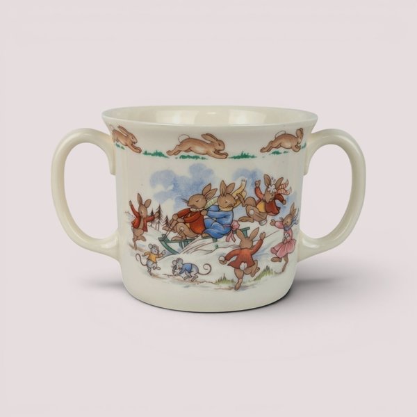 Vintage 1984 Royal Doulton Bunnykins two-handled ceramic cup featuring a colorful winter scene of rabbits sledding.