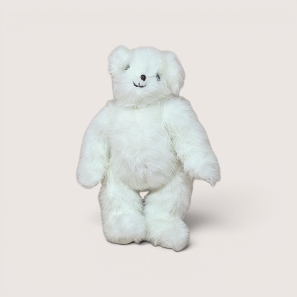A fluffy white plush teddy bear standing upright and smiling, centered on a beige background.