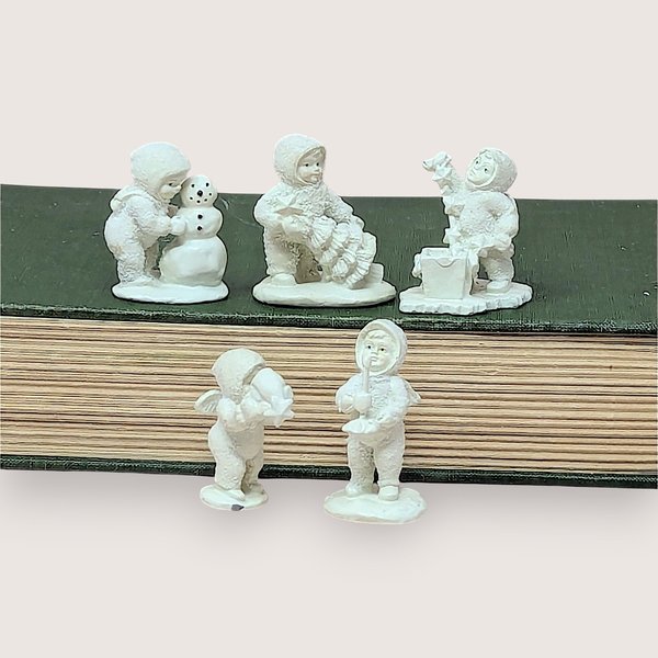 Collection of five white metal miniature Department 56 Snowbabies figurines shown in a row.