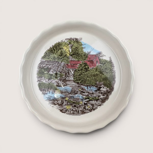 Vintage Johnson Brothers Friendly Village ceramic pie plate featuring a scenic red covered bridge illustration and scalloped edge.