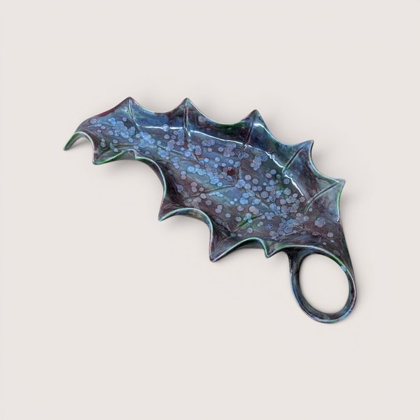 Vintage mid century handmade ceramic holly leaf dish featuring a striking blue and purple reactive drip glaze with an integrated loop handle.