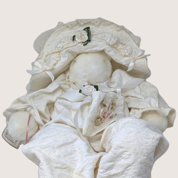 A large vintage 1994 Bunnies By the Bay artisan plush bunny doll named Evangeline wearing an ivory quilted romper and bonnet.