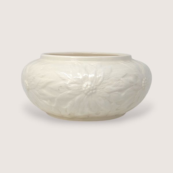 Vintage 1997 cream ceramic bowl featuring embossed holiday poinsettia flower designs around the sides.