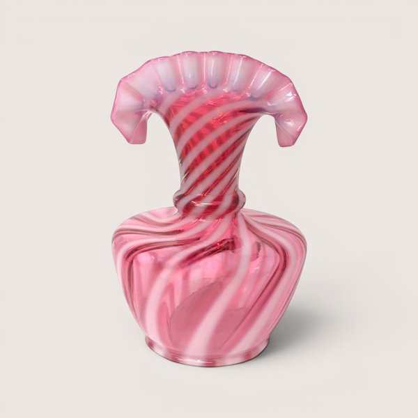 A pink and white spiral swirl opalescent glass fan top vase with a wide flattened ruffled rim on a beige backdropA pink and white spiral swirl opalescent glass jack in the pulpit vase on a light beige background