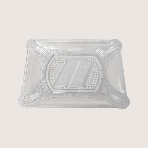 Antique rectangular clear pressed glass bread plate featuring an embossed open Bible text on a solid cream backdrop.