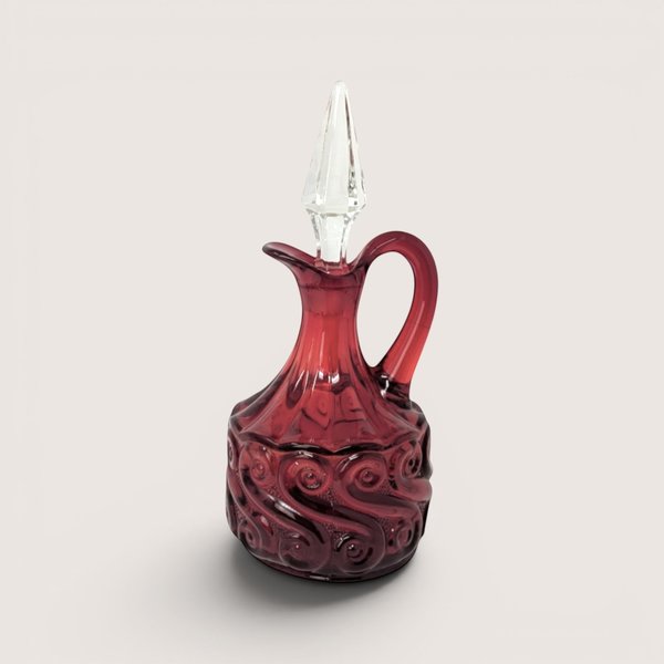 Vintage Fenton ruby red glass cruet with a molded scroll pattern and a clear pointed crystal stopper.