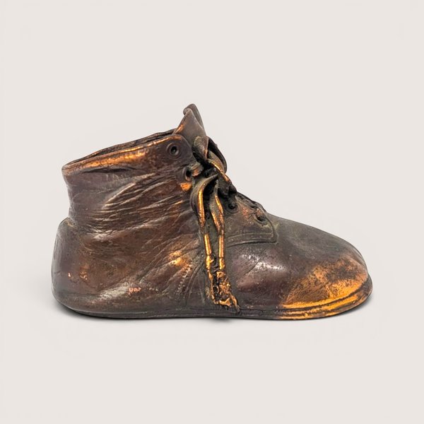 Heavy vintage bronze clad mid century high top baby shoe paperweight with a dark metallic copper patina.