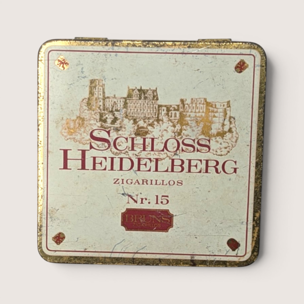 Vintage empty square Schloss Heidelberg German zigarillos tin with a gold castle illustration and burgundy text.