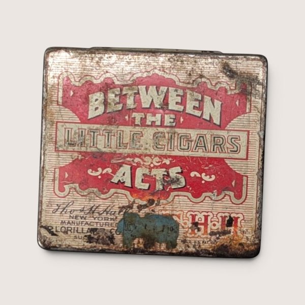 Vintage heavily weathered empty red and white Between the Acts Little Cigars pocket tin.