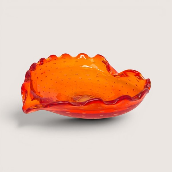 Vintage orange and red Murano amberina bullicante art glass ashtray with a ruffled edge.