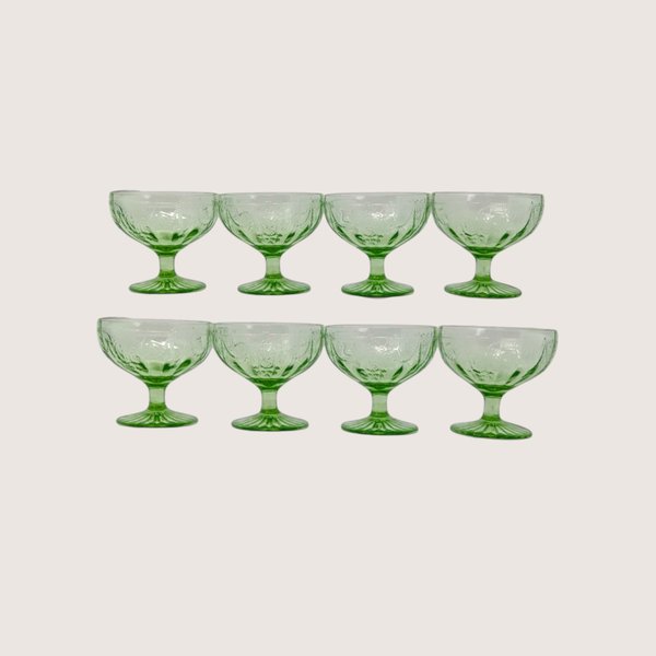 Set of eight vintage Anchor Hocking cameo green depression glass sherbet cups arranged in two rows.