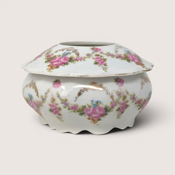 Antique M.Z. Austria porcelain hair receiver jar decorated with pink floral swags and a scalloped base.